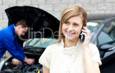 Man repairing car of busy woman
