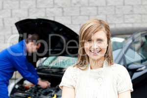 Man repairing car of smiling woman