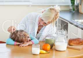 Blond mother and daughter having breakfast