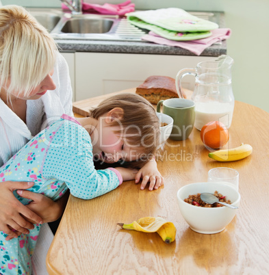 Young mother and daughter having breakfast