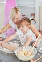 Concentrated woman baking with her daughter