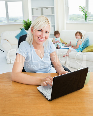 Blond mother using laptop