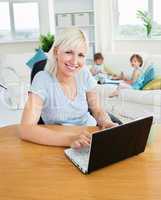 Blond mother using laptop