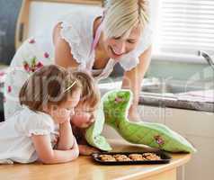 Smiling woman baking cookies with her daughters