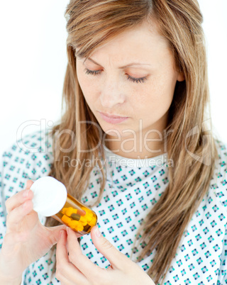 Concentrated female patient looking at her pills