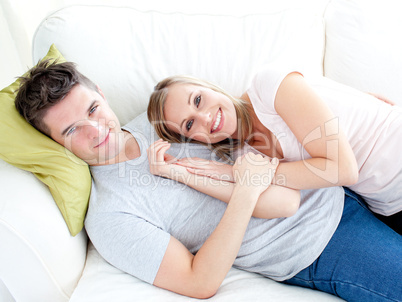 Caress young couple lyingo together on the sofa