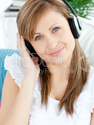 Portrait of a delighted woman listen to music with headphones