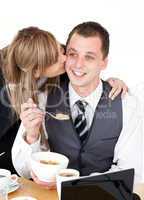Beautiful blond businesswoman giving her smiling boyfriend a kis