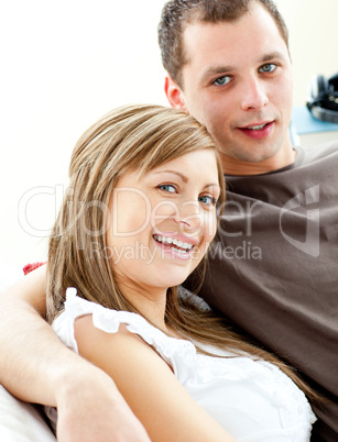 Portrait of a hugging couple sitting on a sofa