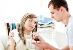 Loving boyfriend holding a thermometer of his ill girlfriend