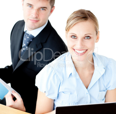 Beautiful couple of businesspeople smiling at camera using lapto