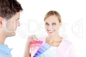Smiling young woman choosing colors for painting a room