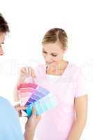 Happy young woman choosing colors for painting a room