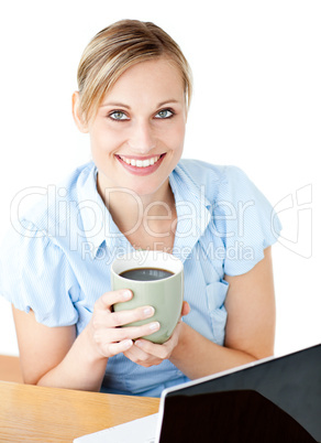 Glowing businesswoman drinking coffee smilng at the camera