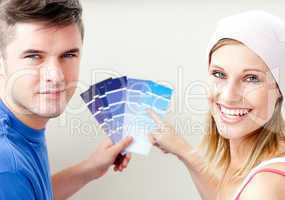 Cheerful couple with color samples for painting a room