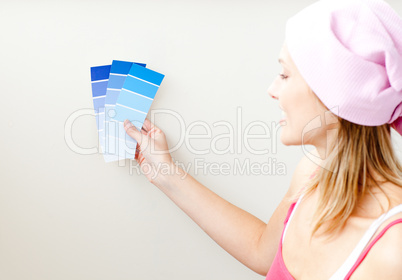 Attractive young woman choosing color for painting a room