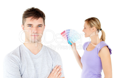 Young caucasian couple choosing colors for painting their room