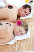 Young couple enjoying a back massage with stone