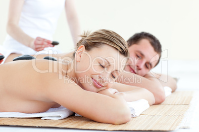 Caucasian young couple having a massage with hot stone