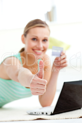 Cute young woman with thumb up holding a card