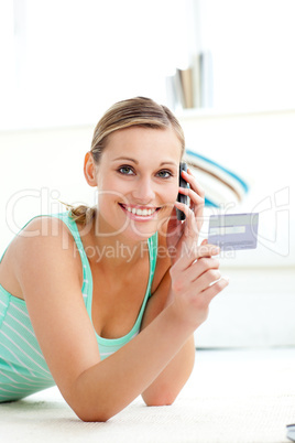 Attractive caucasian woman talking on phone holding a card
