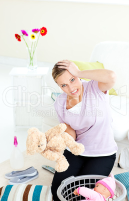 Blond young woman with headache putting toys into a basket