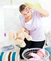 Exhausted young woman putting toys into a basket