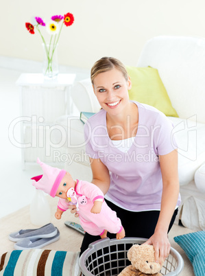 Merry young mother putting toys into a basket