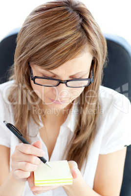 Assertive businesswoman taking notes on her notebad