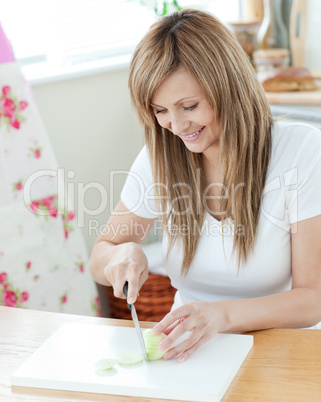 Pretty young woman cutting onions in the kitchen