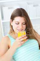 Caucasian young woman drinking orange juice