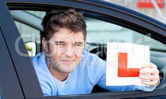 Positvie young male driver holding a L sign