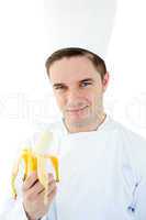 Charming male cook holding banana smiling at the camera
