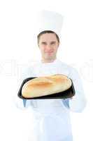 Smiling male cook holding a bread into the camera