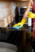 Young caucasian woman cleaning the oven