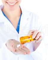 Close-up young female doctor holding pills