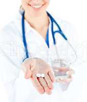 Close-up of caucasian doctor holding pills and water