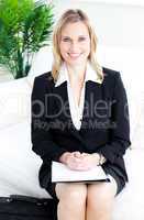 Confident blond businesswoman smiling at the camera sitting on a
