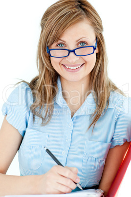 Ambitious businesswoman taking notes smiling at the camera