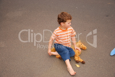 Kind sitzt auf der Straße