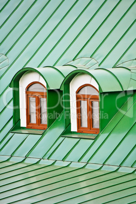 Roof dormers on the roof covered with green iron plates