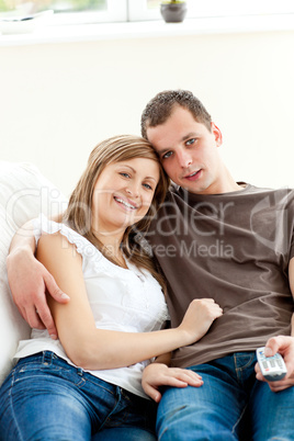 Portrait of an embracing couple watching television