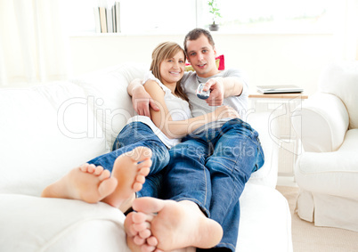 Positve caucasian couple lying together on the couch