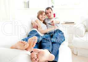 Positve caucasian couple lying together on the couch