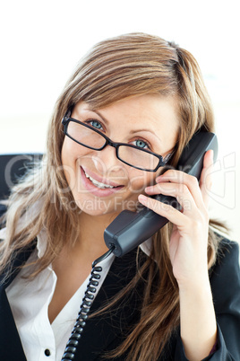 Assertive businesswoman talking on phone looking at the camera