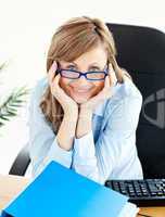 Charming businesswoman smiling at the camera sitting at her desk