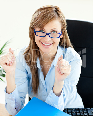 Lively businesswoman smiling at the camera with thumbs up