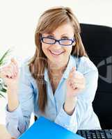 Lively businesswoman smiling at the camera with thumbs up