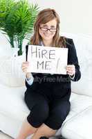 Smiling businesswoman holding a paper with the tite"Hire Me!"