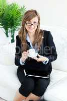 Bright businesswoman holiding a cup smiling at the camera